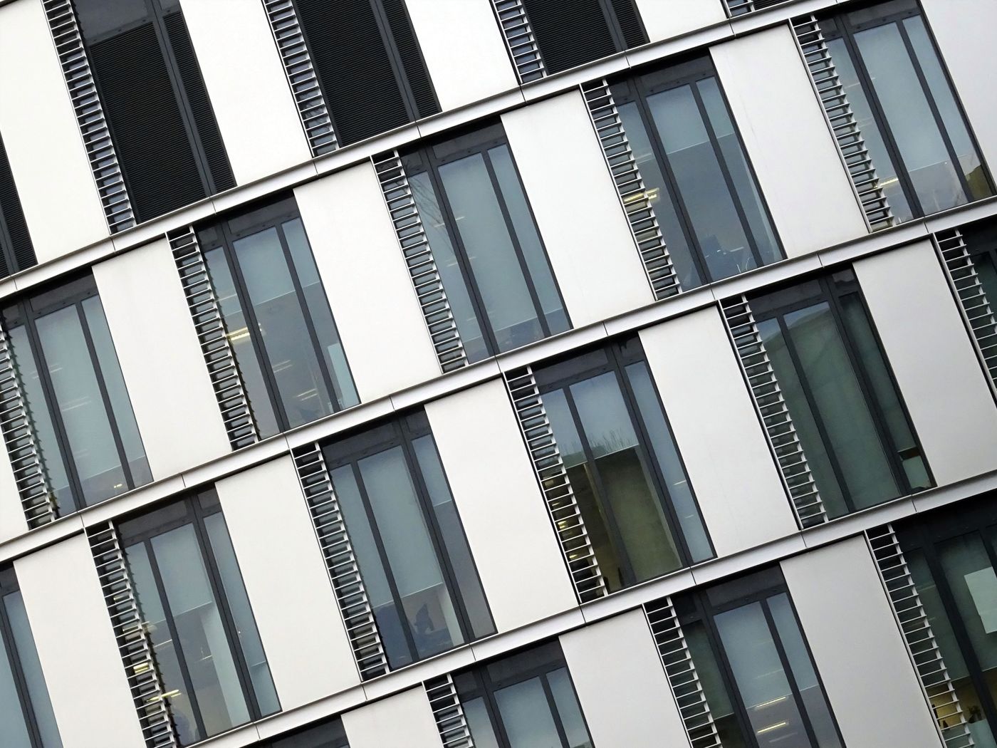 Weiße Bürofassade mit vertikalen Lamellen